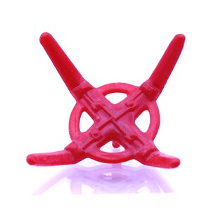 Könnte beinhalten: Ein roter Plastikfuß mit vier Armen, die ein X bilden. Der Fuß ist dafür ausgelegt, einen Weihnachtsbaum oder ein anderes Dekorationsobjekt zu halten.