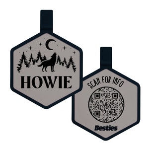 May include: A gray hexagonal luggage tag with a black wolf howling at the moon in a forest scene. The tag says "HOWIE" and has a black strap. The back of the tag has a black and white QR code with the text "SCAN FOR INFO" and "Besties".