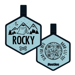May include: Two-sided, light blue pet tag with a black hexagon shape and a black loop. One side features a camping scene with the name "Rocky". The other side has a QR code and the word "Besties".