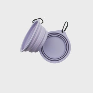 May include: Two light purple collapsible bowls made of flexible silicone. Each bowl features a circular design with concentric ridges for folding and a black metal carabiner attached to a small tab on the rim for easy carrying and attachment.