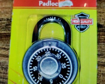 Peut inclure: Un cadenas à combinaison argenté avec un cadran noir et des chiffres de 0 à 40. Le cadenas a un diamètre de 5 cm et est étiqueté "Cadenas à combinaison réinitialisable".