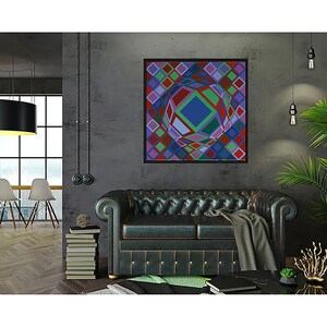 May include: A framed abstract geometric art piece with a black frame, featuring a colorful design of squares and a central sphere. The artwork hangs above a dark green leather sofa in a modern living room setting.