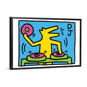 May include: A framed pop art print featuring a yellow figure of a dog-like creature DJing. The artwork has a blue background with the word "DJ" in the upper right corner. The DJ is holding a pink record and has two turntables.