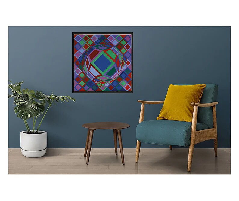 May include: A framed abstract geometric art print with a black frame. The artwork features a colorful, three-dimensional design with squares and diamond shapes in shades of red, green, blue, and purple. The art is displayed on a dark blue wall.