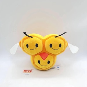 Pode incluir: Um brinquedo de pelúcia amarelo em forma de abelha sorridente com três rostos. Possui antenas pretas, asas brancas e um detalhe vermelho no peito. O brinquedo tem o texto "KPTD" e "N0440" em uma etiqueta.