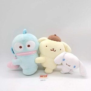 May include: Three plush toys: a light blue creature with large eyes, a yellow dog-like character with a brown hat, and a small white bunny with blue accents. The toys are soft and cuddly, perfect for children.