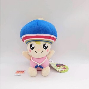 May include: A soft toy character with a blue mushroom-shaped hat, pink outfit, and smiling face. The toy has a tag attached. The character has a light skin tone and is wearing a pink outfit with a white rope necklace.