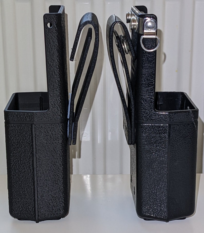 May include: Two black plastic tool holders with belt loops. Each holder has a textured surface and a metal clip.