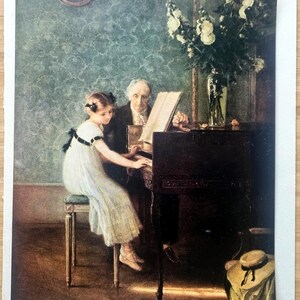 May include: An antique print showing a young girl in a white dress playing a piano, with an older man beside her. A vase of white flowers sits atop the piano. The background features a patterned wall and a clock.