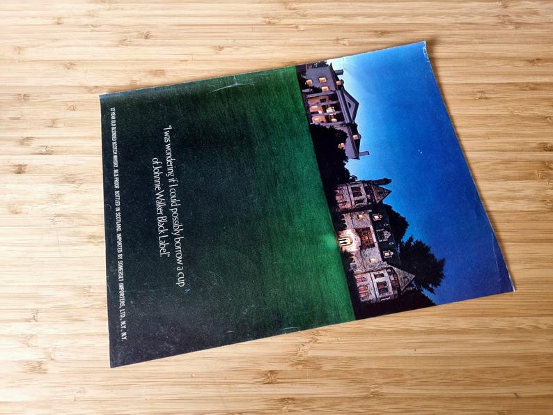 May include: A magazine advertisement featuring a nighttime scene of a large house with lights on, set against a dark blue sky. The text reads, "I was wondering if I could possibly borrow a cup of Johnnie Walker Black Label."