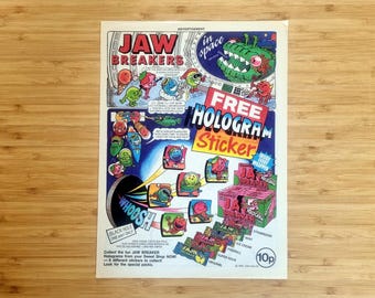 ヴィンテージ雑誌広告プリント、ジョーブレイカーズキャンディ広告、1990年代のお菓子ホログラムステッカープロモーション、レトロな子供時代のノスタルジア、カラフルなウォールアート