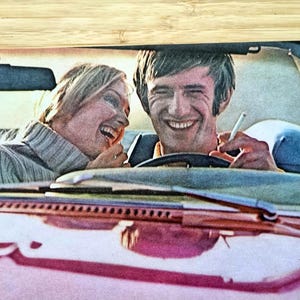 Puede incluir: Fotografía vintage de un hombre y una mujer riendo en un coche. El hombre sostiene un cigarrillo. El coche es rosa y la gente lleva ropa vintage. La imagen tiene una estética retro.