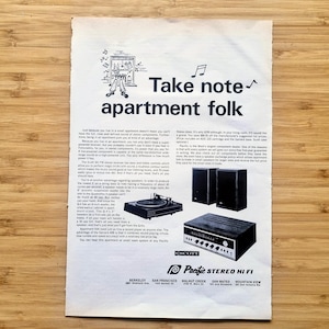 Puede incluir: Anuncio publicitario vintage de Pacific Stereo Hi Fi, con un tocadiscos, un amplificador y altavoces. El anuncio incluye el texto "Take note apartment folk" e ilustraciones. El anuncio está impreso en papel blanco con fondo de madera.