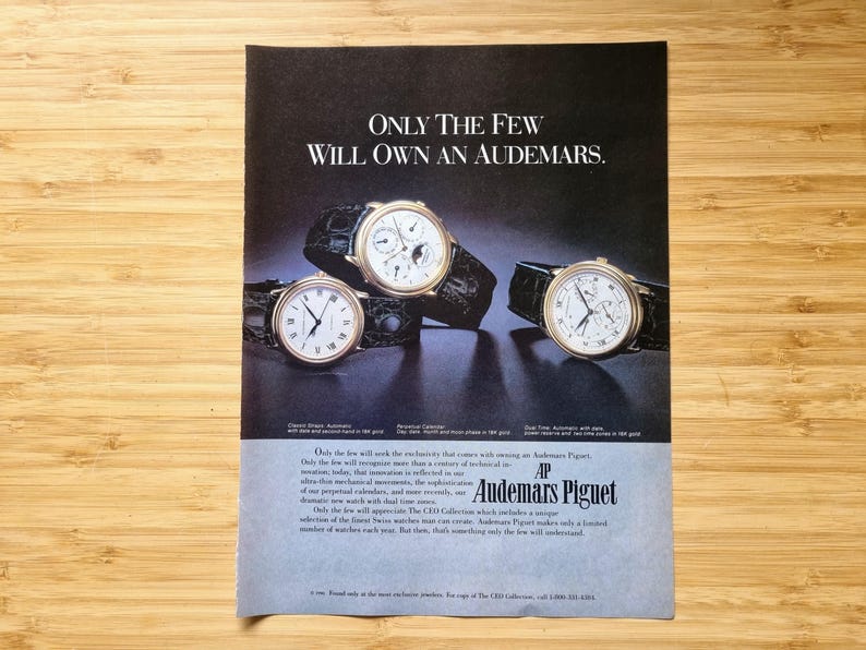 May include: An advertisement featuring three Audemars Piguet watches with black leather straps. The watches have gold-toned cases and white faces. The text reads "ONLY THE FEW WILL OWN AN AUDEMARS."
