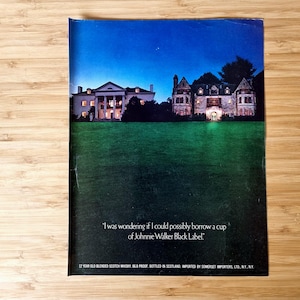 Original vintage Johnnie Walker Black Label magazine advertisement showing a nighttime view of illuminated historic mansion buildings set behind a dark lawn, featuring the brand’s famous whisky slogan and classic luxury Scotch advertising imagery, presented as an authentic collectible print with visible magazine fold.