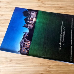 May include: A magazine with a blue and green gradient background featuring a nighttime landscape with illuminated buildings. Text on the magazine reads, "I was wondering if I could possibly borrow a cup of Johnnie Walker Black Label."