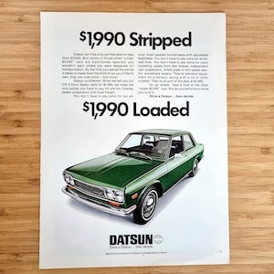 May include: Vintage advertisement for a green Datsun car. The ad features the text "$1,990 Stripped" and "$1,990 Loaded". The car is a two-door sedan with chrome accents and white-wall tires. The Datsun logo is at the bottom.