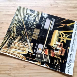 May include: An advertisement featuring a bottle of Black Label Scotch whisky. The image has a black, gold, and brown color scheme, with text that reads "The 12 year old Scotch that commands more respect."