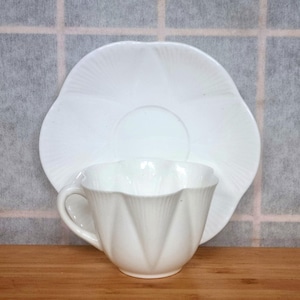 Taza y platillo Shelley Dainty White, porcelana fina inglesa, forma delicada con borde festoneado, platillo en forma de flor, juego minimalista de té blanco de la década de 1930.