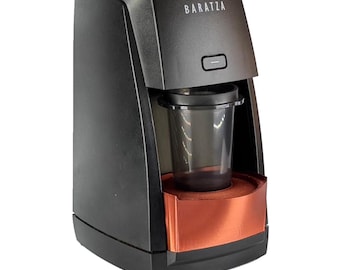 Puede incluir: Molinillo de café negro y cobrizo con la marca "Baratza" impresa en la parte delantera. El molinillo tiene un recipiente de plástico transparente y una base de color cobre. La parte superior tiene un dial con números.