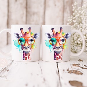 May include: Two white ceramic mugs with a colorful watercolor giraffe wearing orange sunglasses. The giraffe is surrounded by colorful watercolor splatters.
