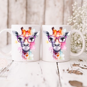 May include: Two white ceramic mugs with a watercolor giraffe design wearing purple glasses. The giraffe is surrounded by colorful watercolor splatters.