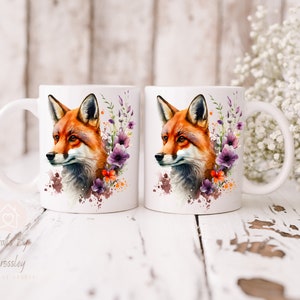 May include: Two white ceramic mugs with a watercolor design of a fox with purple and orange flowers. The mugs have a handle on the right side.