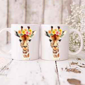 May include: Two white ceramic mugs with a giraffe wearing a floral crown printed on them. The giraffe has brown spots and a light brown face. The flowers are yellow, pink, and orange.