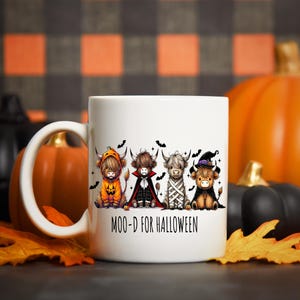 Pu&ograve; includere: Tazza in ceramica bianca con quattro mucche delle Highlands vestite con costumi di Halloween. Le mucche sono vestite da zucca, vampiro, mummia e strega. La tazza ha la scritta "MOO-D FOR HALLOWEEN".