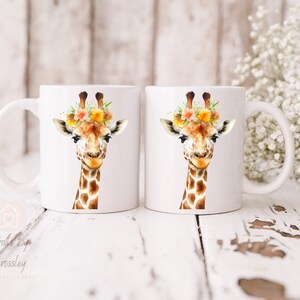 May include: Two white ceramic mugs with a watercolor illustration of a giraffe wearing a flower crown. The giraffe has a brown and white patterned coat and a friendly expression.