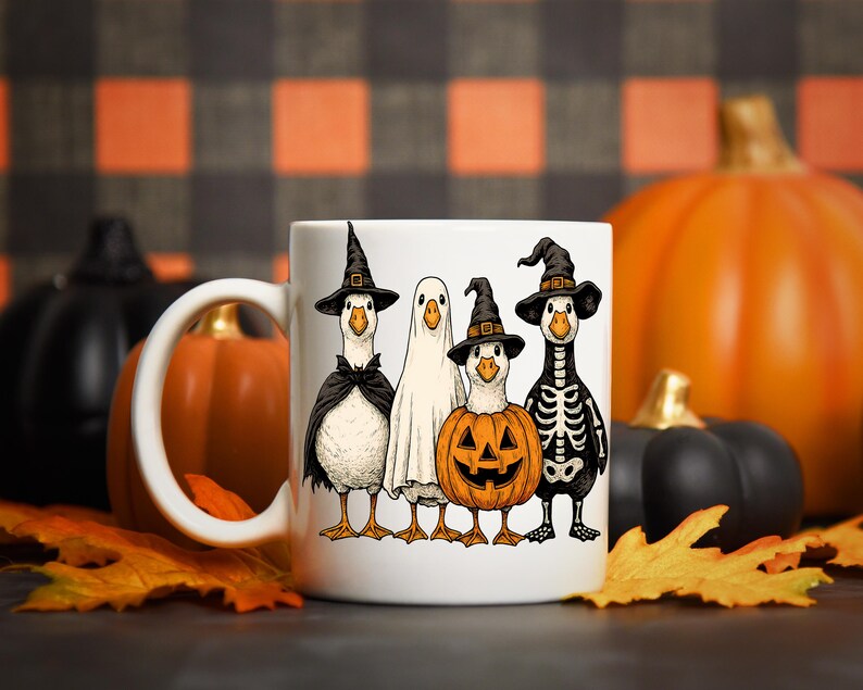 Pu&ograve; includere: Tazza in ceramica bianca con un design a tema Halloween. Raffigura quattro oche dei cartoni animati in costume: una strega, un fantasma, una zucca e uno scheletro. Le oche sono in piedi insieme. Lo sfondo include zucche e foglie autunnali.