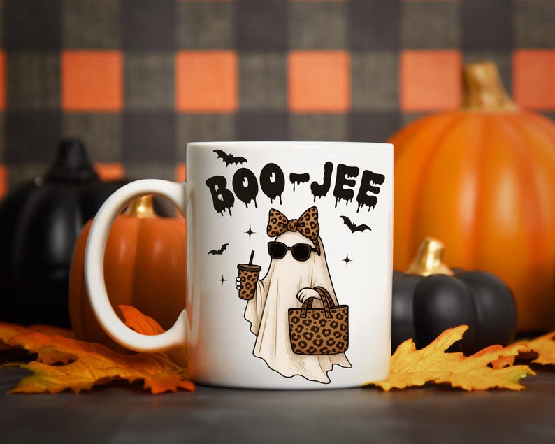 Pu&ograve; includere: Tazza in ceramica bianca con la scritta "BOO-JEE" in nero gocciolante. La tazza presenta un fantasma dei cartoni animati con occhiali da sole, un fiocco leopardato e porta una borsa e un caff&egrave; con stampa leopardata. Anche pipistrelli e stelle nere sono sulla tazza.