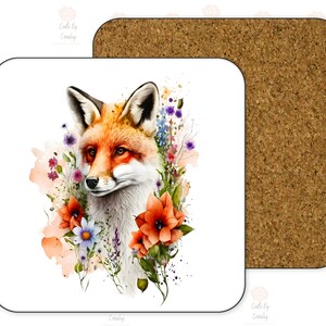 May include: A white ceramic coaster with a watercolor illustration of a red fox surrounded by colorful flowers. The fox is looking to the left and has a white chest and a bushy tail.