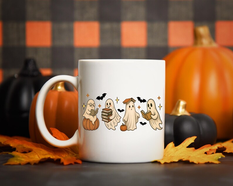 Pu&ograve; includere: Tazza in ceramica bianca con un design a tema Halloween. Presenta fantasmi dei cartoni animati che leggono libri, seduti su zucche e circondati da pipistrelli e stelle. Lo sfondo include zucche e foglie autunnali.