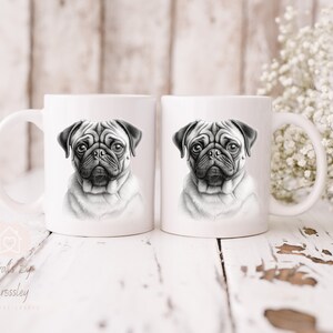 May include: Two white ceramic mugs featuring a black and white illustration of a pug dog on each mug.