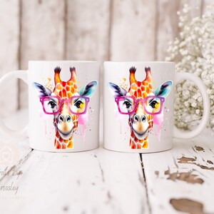 May include: Two white ceramic mugs with a watercolor illustration of a giraffe wearing pink glasses. The giraffe is painted in shades of orange, yellow, and pink.