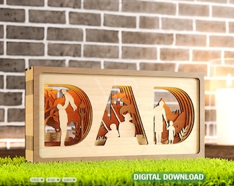 Puede incluir: Un letrero de madera con la palabra "DAD" recortada en el centro. El letrero está iluminado desde atrás, creando un efecto de sombra. La palabra "DAD" está rodeada de siluetas de un padre y un hijo disfrutando de diversas actividades juntos, como pescar, jugar en el parque y caminar por el bosque.