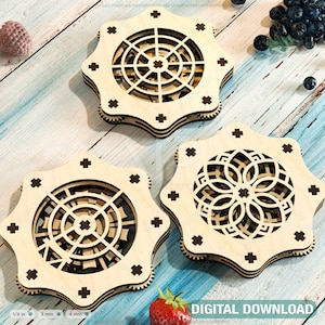 May include: Three wooden coasters with intricate laser-cut designs. The coasters are in the shape of a star with a circular design in the center. The designs feature geometric patterns and are in shades of brown.