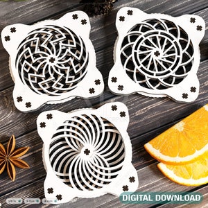 Puede incluir: Tres posavasos de madera cortados con láser con intrincados diseños geométricos. Los posavasos son cuadrados con esquinas redondeadas y presentan un patrón circular en el centro. Los diseños recuerdan a un mandala o una flor.
