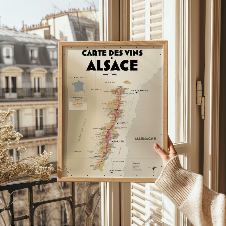 May include: A vintage-style map of the Alsace wine region in France. The map is printed on cream-colored paper and features a detailed outline of the region's vineyards. The title "Carte des Vins d'Alsace" is printed in black at the top of the map.