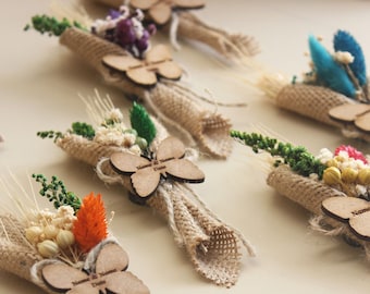 May include: A collection of small, burlap-wrapped bouquets with dried flowers and a wooden butterfly charm attached. Each butterfly charm has a personalized message.