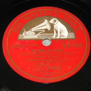 Könnte beinhalten: Vintage Schallplatte mit rotem Etikett und der Aufschrift "HIS MASTER'S VOICE". Das Etikett zeigt eine Illustration eines Hundes, der einem Grammophon zuhört. Die schwarze Schallplatte trägt den Titel "THE ROSE OF TRALEE".