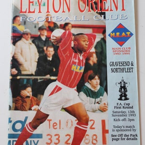 May include: A Leyton Orient Football Club matchday programme for a game against Gravesend & Northfleet. The programme features a photo of a player in a red and white striped jersey with the team's sponsor, HEAT, on the front. The programme is dated Saturday, 13th November 1993, and costs £1.20.
