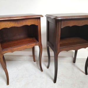 May include: A pair of matching dark brown wooden nightstands, each featuring a rectangular top, an open storage compartment with a scalloped apron detail, and four slender, curved legs that extend outward from the base of the unit.