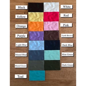 May include: A color chart with 15 different colors, including black, white, red, yellow, orange, pink, purple, earth brown, light blue, dark blue, muted blue, mint green, muted green, dark green, and teal. Each color is represented by a small square with a textured surface.