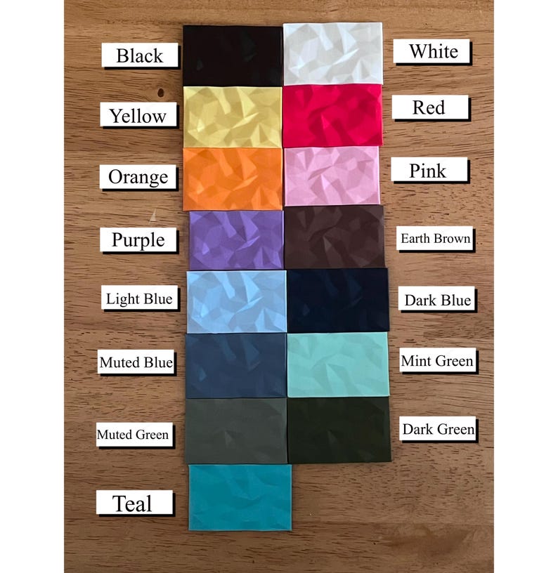 May include: A color chart with 15 different colors, including black, white, red, yellow, orange, pink, purple, earth brown, light blue, dark blue, muted blue, mint green, muted green, dark green, and teal. Each color is represented by a small square with a textured surface.