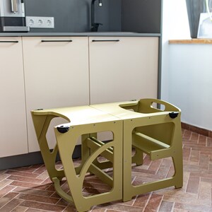Può includere: Un set di tavolo e sedia per bambini in legno verde chiaro. Il tavolo e la sedia sono entrambi pieghevoli e hanno un design semplice.