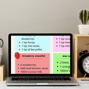 May include: A laptop computer screen displaying a recipe for a strawberry smoothie and a kiwi smoothie. The recipe for the strawberry smoothie includes 6 strawberries, half a small banana, sliced, and 100 ml of coconut milk. The recipe for the kiwi smoothie includes 2 kiwis, 1 orange, and 100 ml of coconut milk.