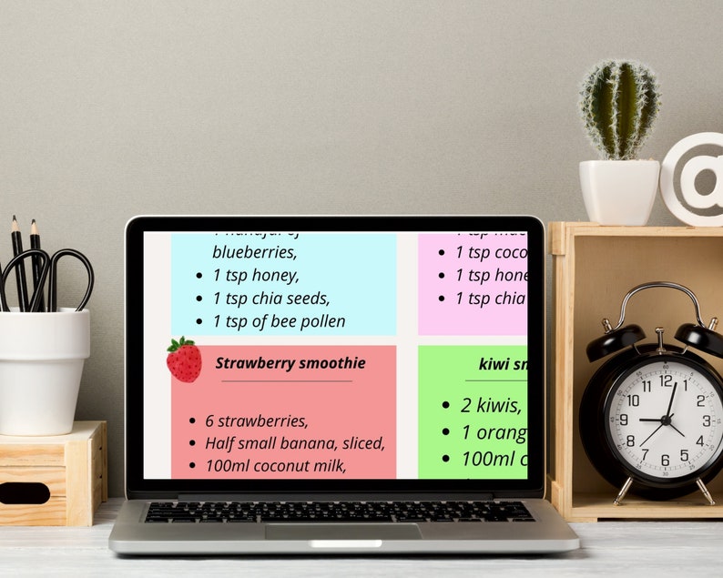 May include: A laptop computer screen displaying a recipe for a strawberry smoothie and a kiwi smoothie. The recipe for the strawberry smoothie includes 6 strawberries, half a small banana, sliced, and 100 ml of coconut milk. The recipe for the kiwi smoothie includes 2 kiwis, 1 orange, and 100 ml of coconut milk.