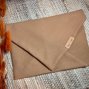 May include: A brown envelope clutch with a small leather tag that says "Super & Pepper".